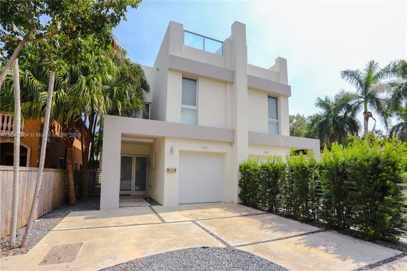 Front view of a modern two-story house with a minimalist design and a garage.