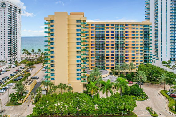 Front view of a multi-story apartment building near the ocean.