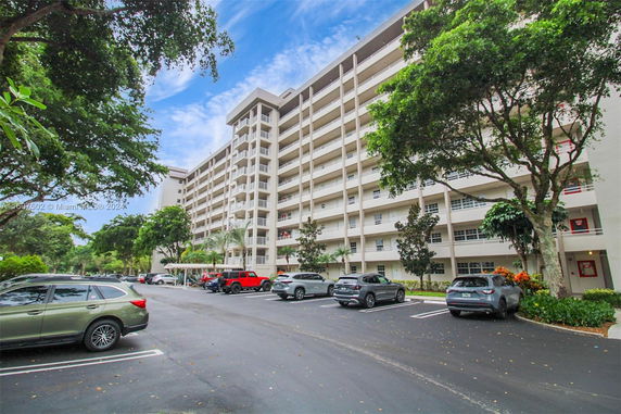 Outdoor parking area in front of a multi-story apartment building.