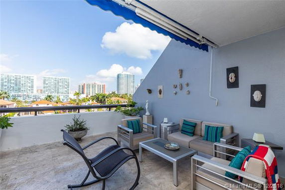 Rooftop terrace with seating area, modern outdoor furniture, and decorative elements on the wall.