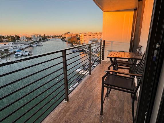 Balcony view overlooking a canal with boats and surrounding buildings.
