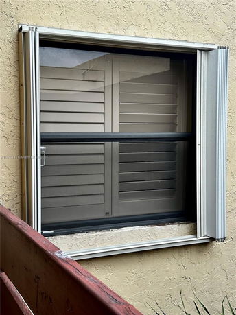 Close-up view of a window on a textured exterior wall.