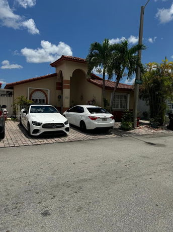 Front view of a house with arched entry and driveway.