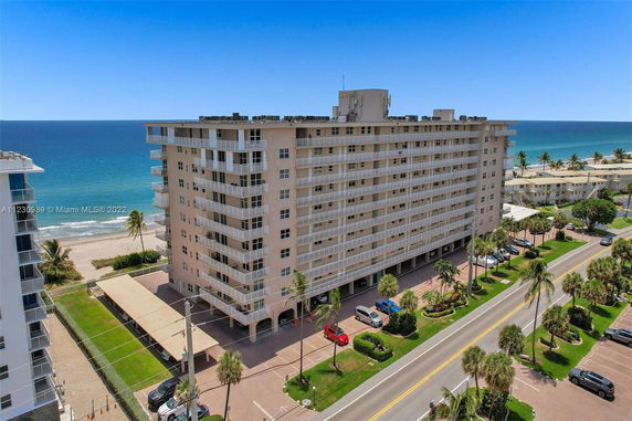 Elevated view of a beachfront multi-story residential building with balconies.