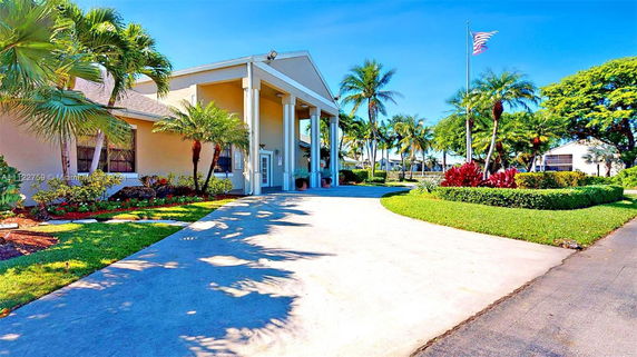 Front view of a building with tall columns and a driveway.