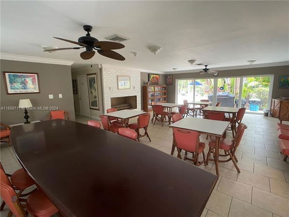 Room with multiple tables and chairs, large windows, and ceiling fans.