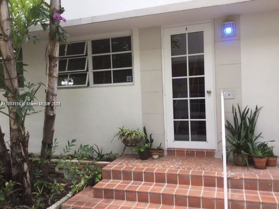 Front view of a house entryway with steps and a glass door.