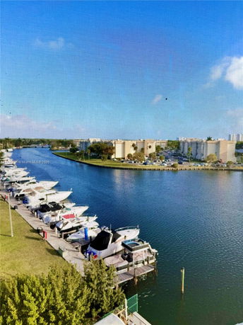 Panoramic view of a river with boats and buildings in the background.