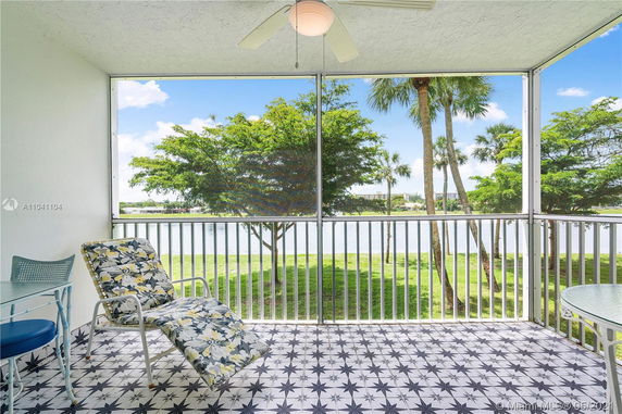 Screened patio with a view of trees and a lake.