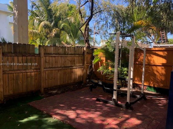 Outdoor area with exercise equipment and wooden fence.