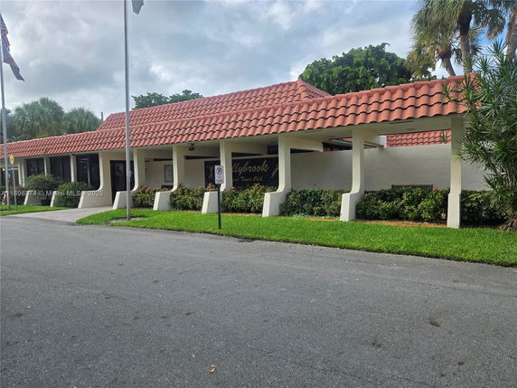 Front view of a building with a red-tiled roof and a covered walkway.