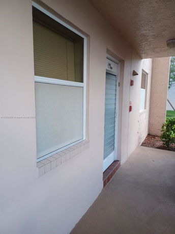 Front view of a building entrance with windows and a door.