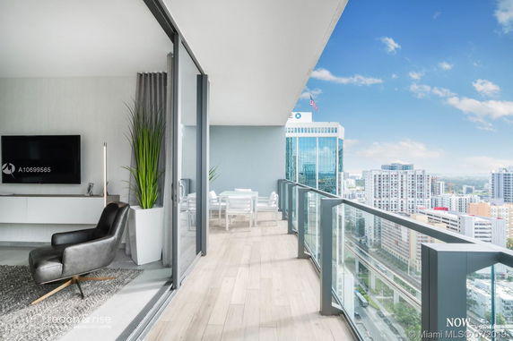 Partial view of a modern high-rise apartment's balcony and the cityscape beyond.