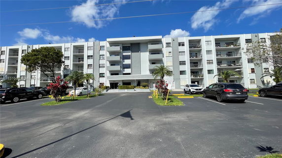 Front view of a multi-story apartment building with balconies.