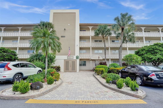 Front view of a multi-story apartment building with balconies.