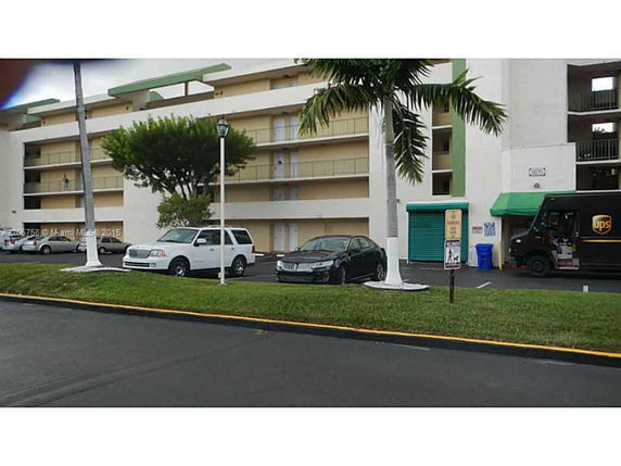 Front view of a multi-story building with an outdoor parking area.