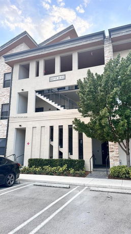 Front view of a multi-story apartment building with exterior staircases.