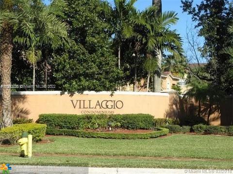 Entrance signage for Villaggio Condominiums with surrounding landscape.