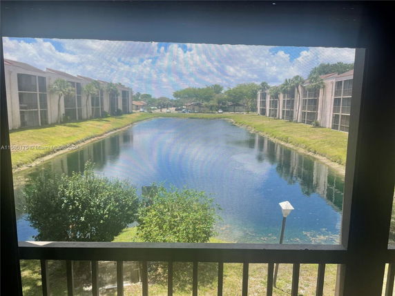 View of apartment buildings and a canal seen through a window screen.