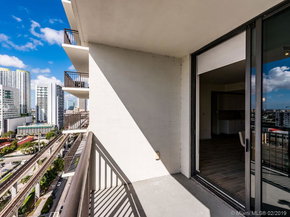 View from a balcony overlooking a cityscape with multiple tall buildings in the background.