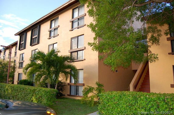 Front view of a multi-story apartment building with brown trim.
