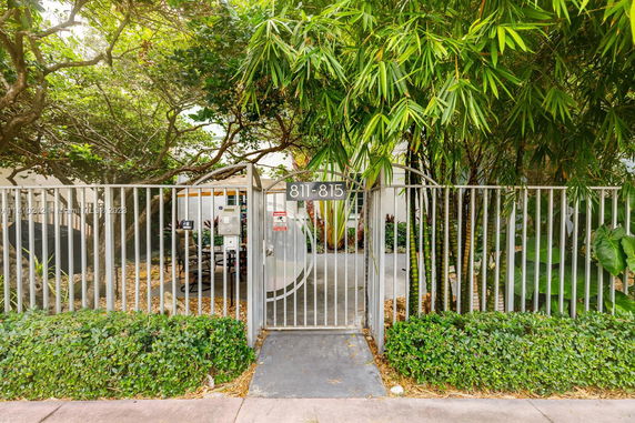 Gated entrance with surrounding greenery and trees.