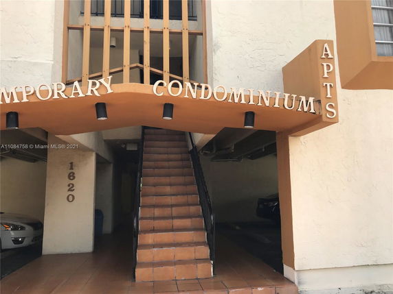 Entrance to a condominium building with prominent signage.