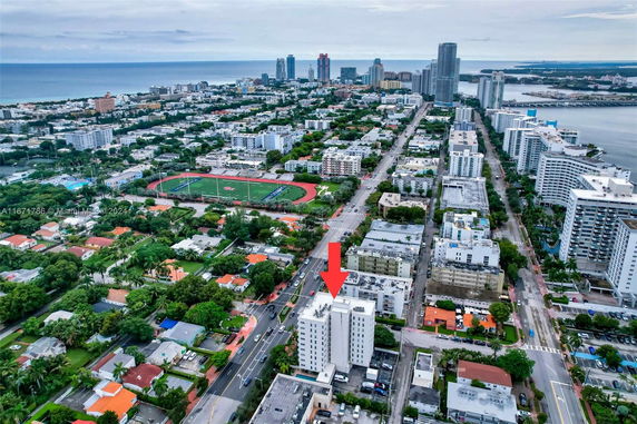 Aerial view of a cityscape with buildings, roads, and a nearby coastline.