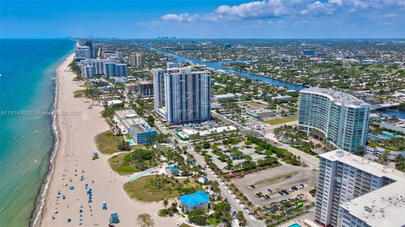 Panoramic view of a coastal city with tall buildings and a beachfront.