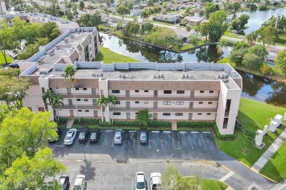 Rear view of a three-story apartment building with a small parking area.