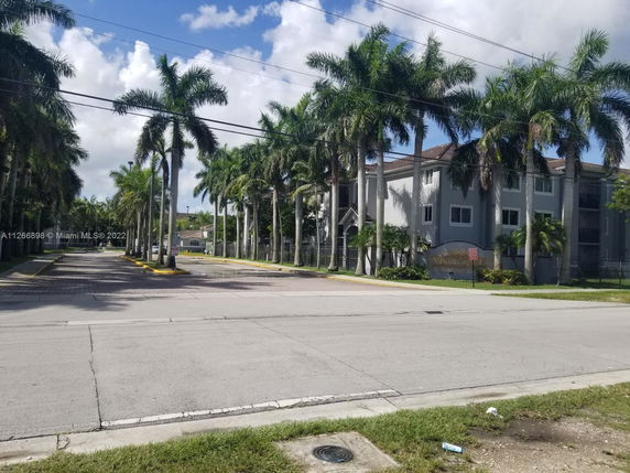 Front view of a multi-story residential building with palm trees.