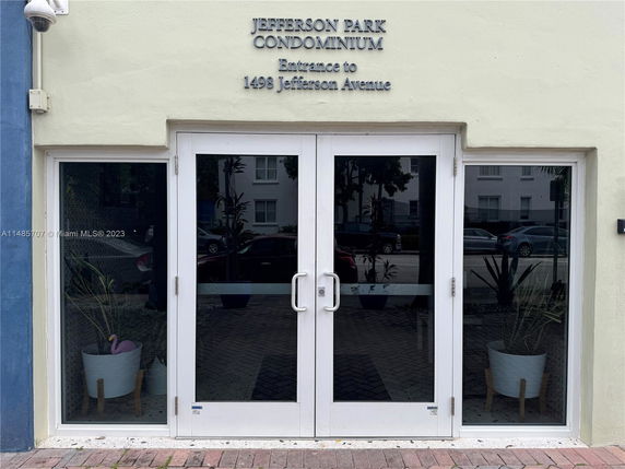Front view of Jefferson Park Condominium entrance with glass doors.