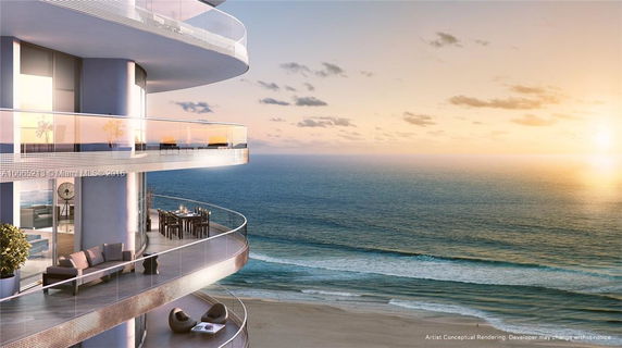 Curved balconies of a modern high-rise building overlooking the ocean at sunset.