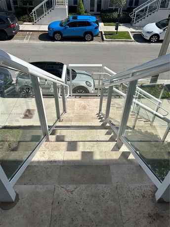 View from a stairway overlooking parked cars on a street