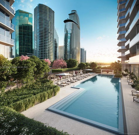 View of a swimming pool area with modern buildings in the background.