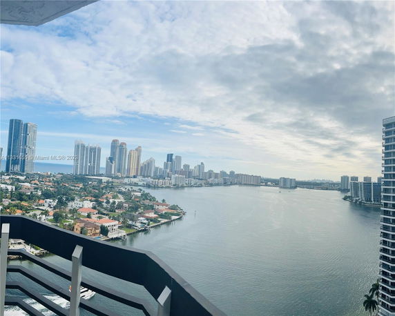 Panoramic view of a body of water with city skyline and residential area.