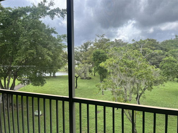 View of trees and grassy area from a balcony.
