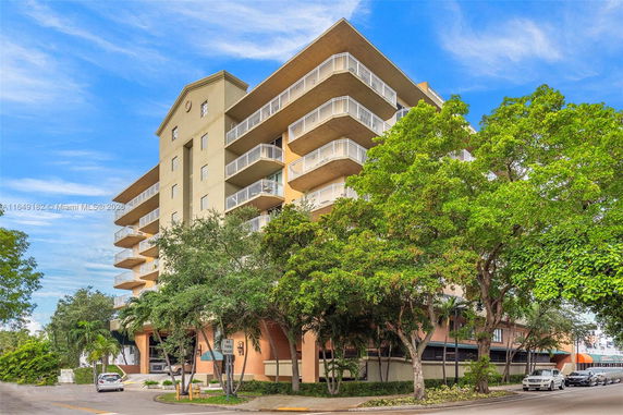 Front view of a multi-story apartment building with balconies.