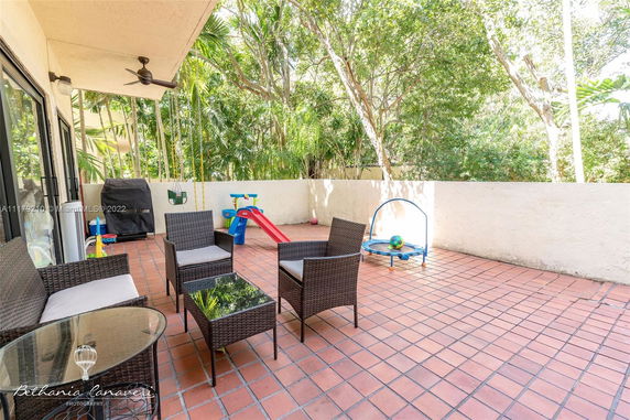 Outdoor patio with furniture and children's play equipment.