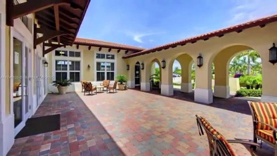 Outdoor lobby area with arched openings and seating arrangement.