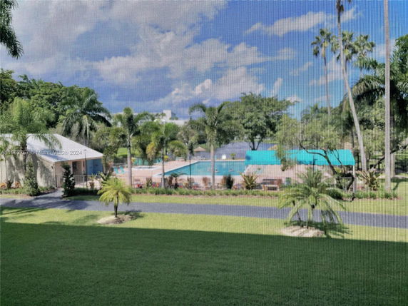 View of an outdoor area with a swimming pool and surrounding greenery.