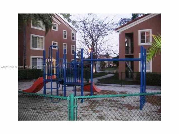 Outdoor playground with slides and climbing structures between buildings.