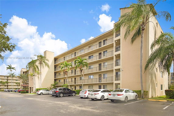 Front view of a multi-story apartment building with balconies.