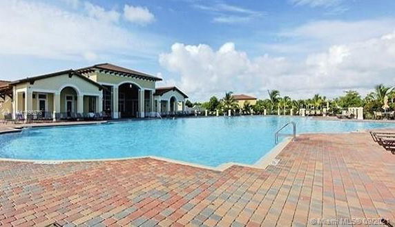 Outdoor swimming pool area with adjacent building.