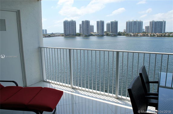 Balcony view overlooking water and tall buildings in the distance.