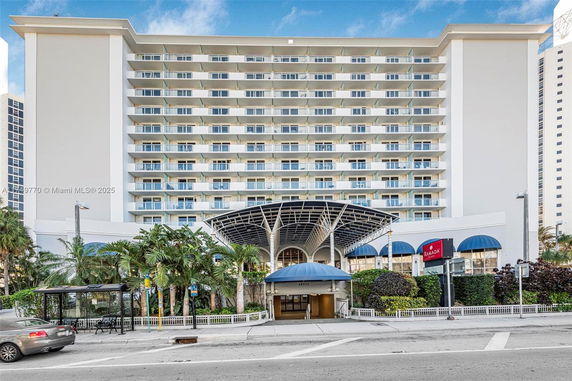 Front view of a multi-story hotel with balconies and a covered entrance.