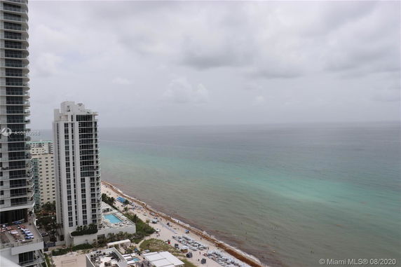 Panoramic view from a high-rise building overlooking the ocean and beach.