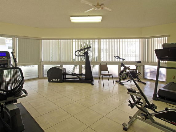 Indoor gym area with exercise equipment and large windows.