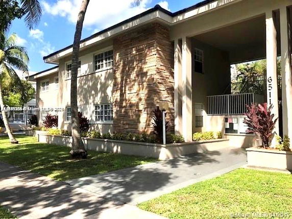 Front view of a two-story residential building with brick and stucco facade.