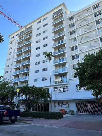 Front view of a multi-story apartment building with balconies.